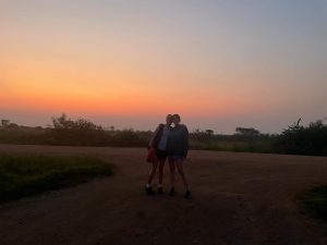 Two students with sunrise in background
